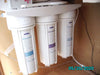 Crystal Quest Triple Under Sink Fluoride Water Filter system installed inside a kitchen cabinet.
