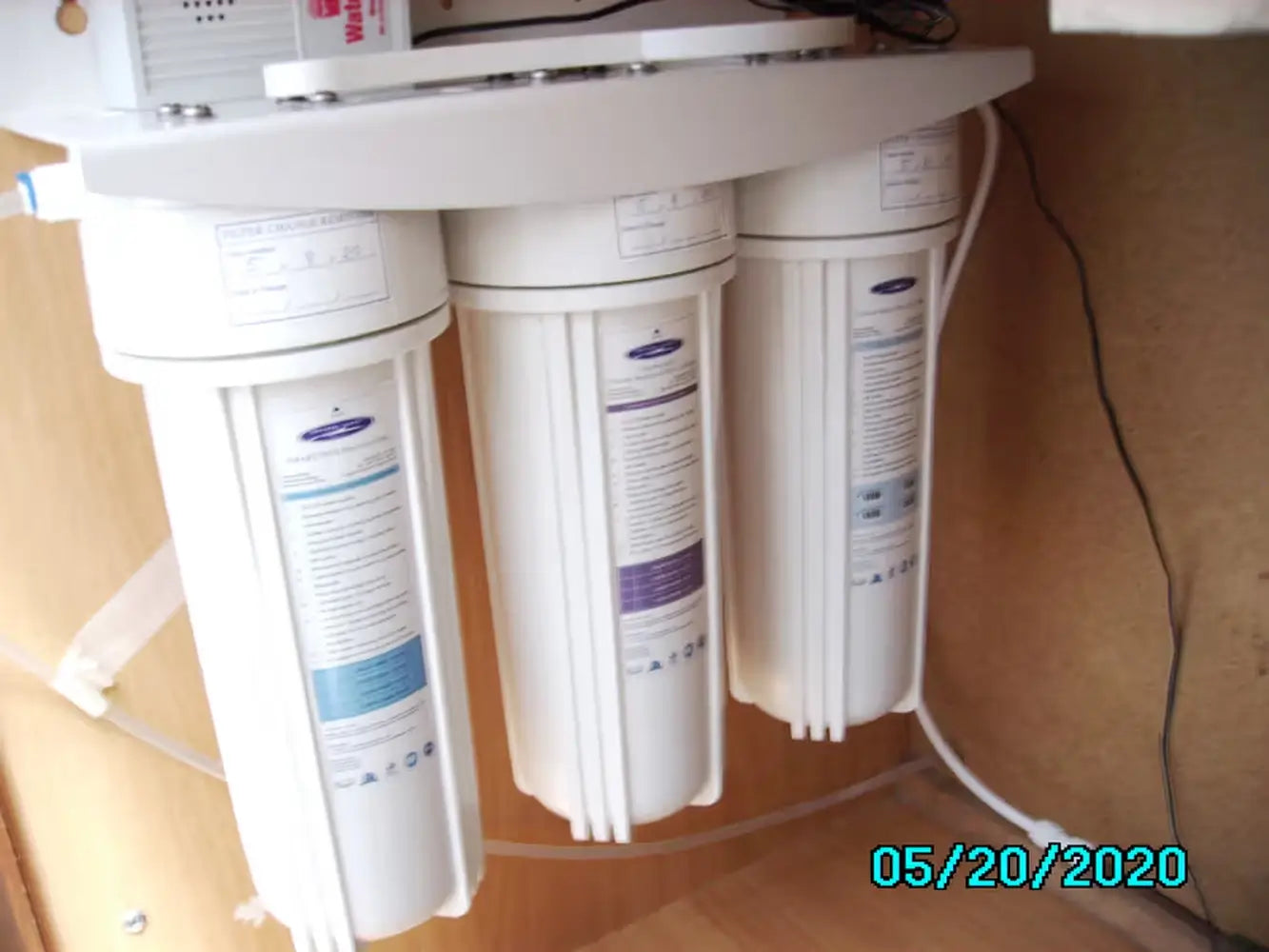 Crystal Quest Triple Under Sink Fluoride Water Filter system installed inside a kitchen cabinet.