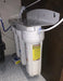 Crystal Quest SMART triple-stage under-sink water filtration system installed inside a kitchen cabinet with wall-mounted bracket and tubing.