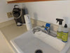 White Crystal Quest Classic Countertop Water Filtration System installed on a kitchen sink faucet next to a coffee maker.