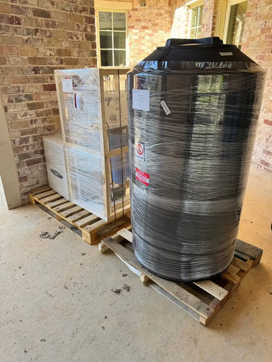 Shipping preparation for a Crystal Quest RO system and large water storage tank, shrink-wrapped and palletized for transport.