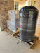 Shipping preparation for a Crystal Quest RO system and large water storage tank, shrink-wrapped and palletized for transport.