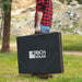Person carrying a Rich Solar MEGA 200W portable solar panel inside its black protective zippered storage bag outdoors.