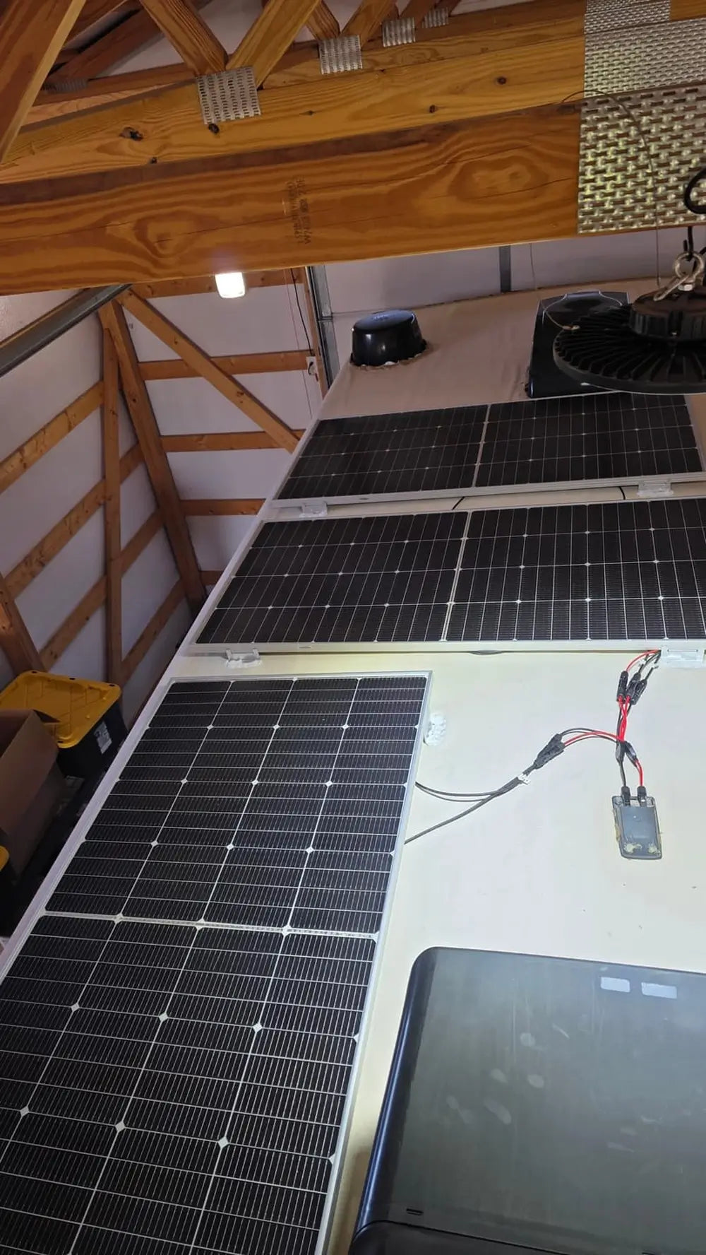 Rich Solar MEGA 250 PRO 24V solar panels installed on an RV roof with visible wiring harness and MC4 connectors inside a garage workshop.