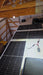 Rich Solar MEGA 250 PRO 24V solar panels installed on an RV roof with visible wiring harness and MC4 connectors inside a garage workshop.