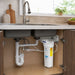 Space-saving under-sink water filter for fluoride removal by Crystal Quest shown with plumbing connections.