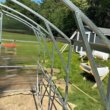 Interior detail of the Magnolia 10x6.5 Greenhouse Kit showing the heavy-duty galvanized steel arched frame and twin-wall polycarbonate panels.