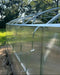 Exterior side view showing the clear polycarbonate panels of the Magnolia 10x13 Greenhouse Kit secured with metal fastening bands.
