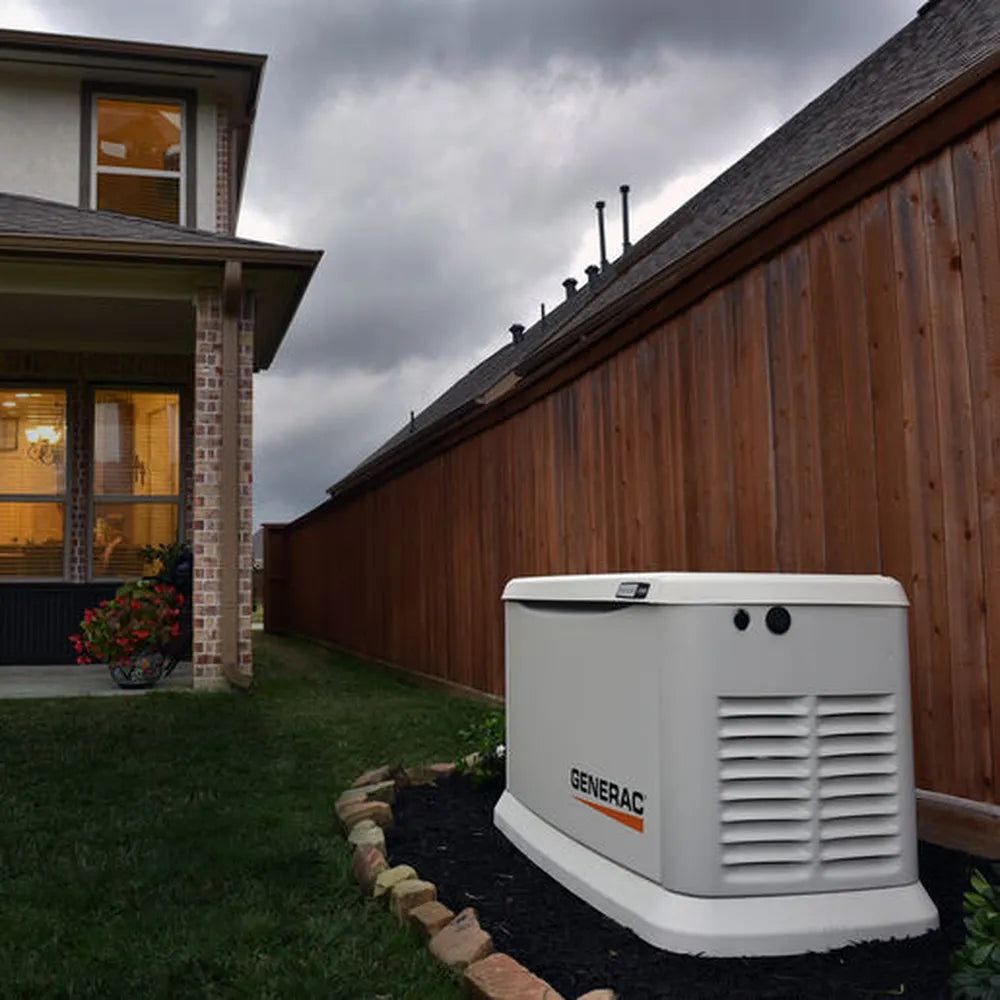 Installed Generac 10kW home standby generator beside house and wooden fence under stormy sky