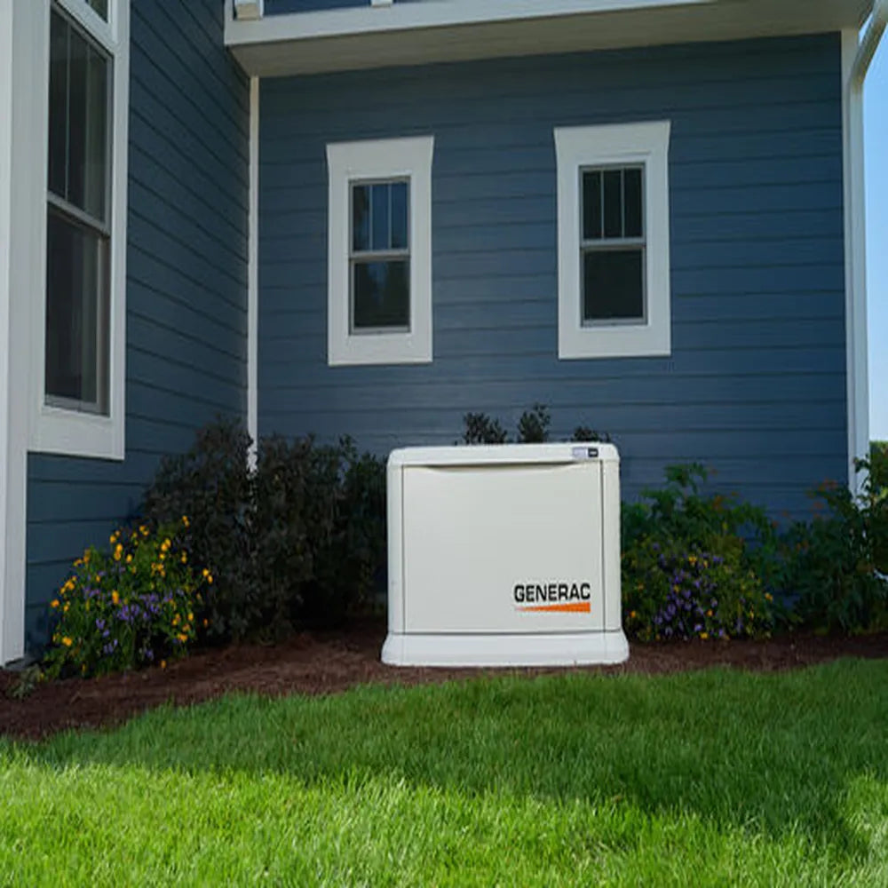Front view of Generac 10kW standby generator installed beside blue house with landscaped garden