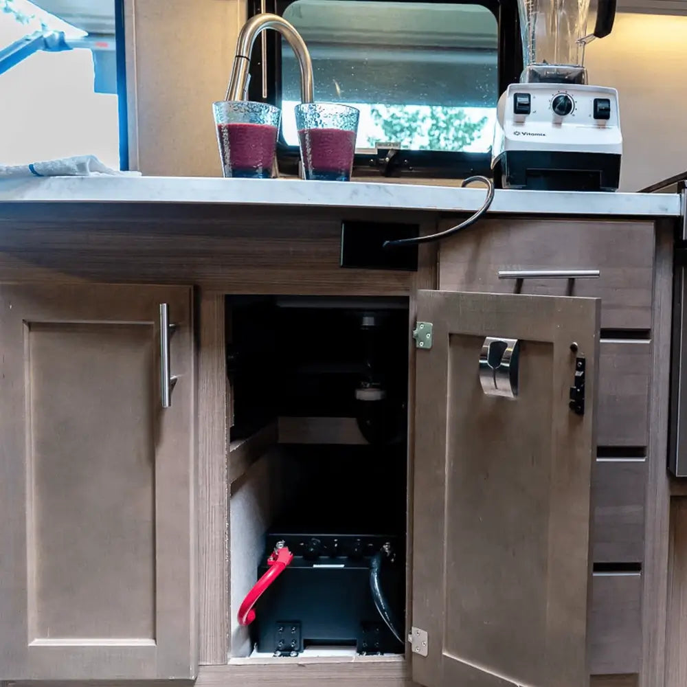 Renogy Pro S1 12V 240Ah LiFePO4 battery installed inside an RV kitchen cabinet under the sink to power off-grid appliances.