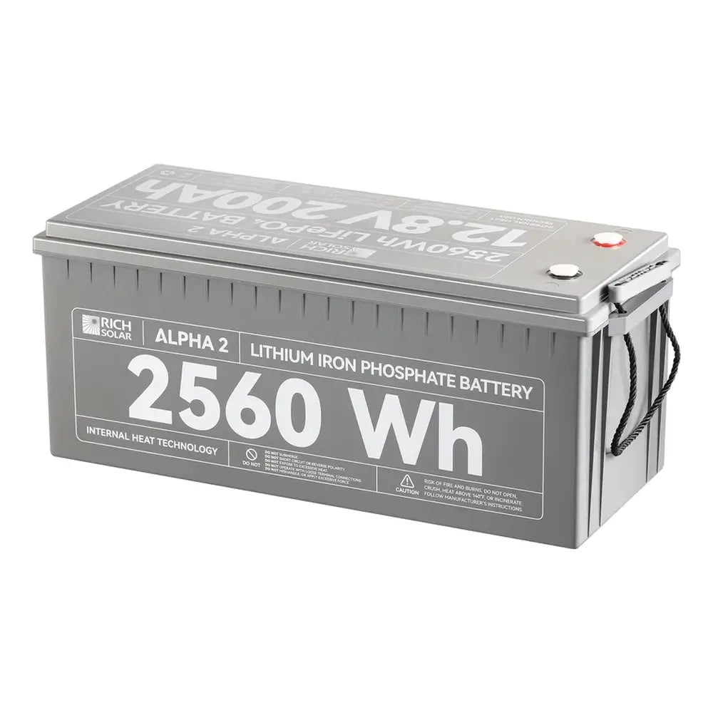 Studio product view of the Rich Solar Alpha 2 12V 200Ah 2560Wh lithium iron phosphate battery with internal heat technology, heavy-duty rope handles, and terminal caps on a white background.