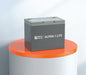 Product display showcase of the gray Rich Solar Alpha 1 Lite 12V 100Ah lithium iron phosphate battery on an orange and white pedestal.