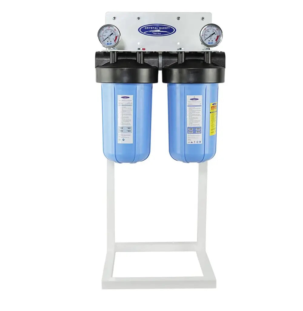 Dual canister Crystal Quest alkalizing water filtration system on a floor stand with dual pressure gauges.