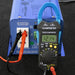 AIMS Power clamp meter connected to blue power inverter outlet showing 12.14V digital reading.