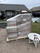 Cardboard boxes of a Rich Solar battery system safely stacked and shrink-wrapped on a wooden delivery pallet in a residential driveway.