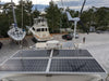 Marine solar panel array and a marine wind turbine mounted on a yacht hardtop in a boatyard for off-grid hybrid power.