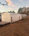 Wide-angle exterior view of the GreenhouseToGrow Magnolia 10x39 Greenhouse Kit during the final stages of garden installation.