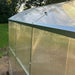 Corner detail of the Magnolia 10x6.5 Greenhouse Kit showing the aluminum trim and secure fastening of the translucent wall panels.