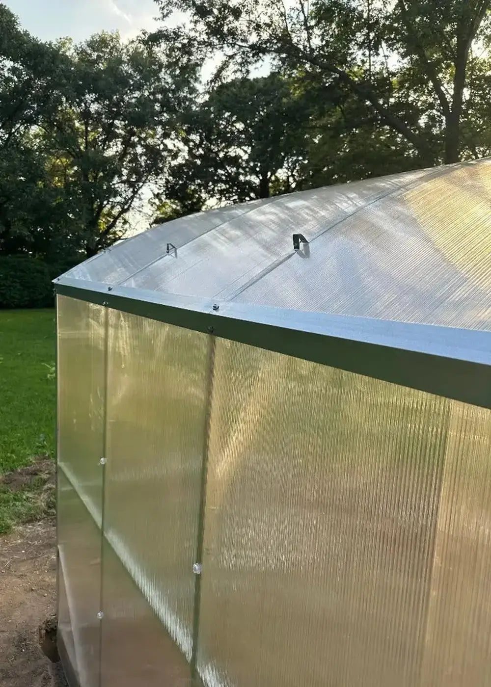 Close-up of the roof line and corner trim assembly on a GreenhouseToGrow Magnolia 10x32.5 heavy-duty greenhouse kit.
