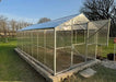Side-angle view of the Daisy 19.5-foot long greenhouse kit with the top half of the Dutch door open for ventilation and airflow.