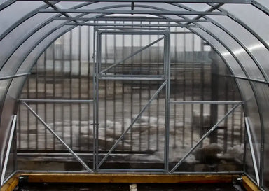 Interior view of the GreenhouseToGrow Camellia 10x39 Greenhouse Kit showing the heavy-duty galvanized steel end wall frame and clear polycarbonate panels.