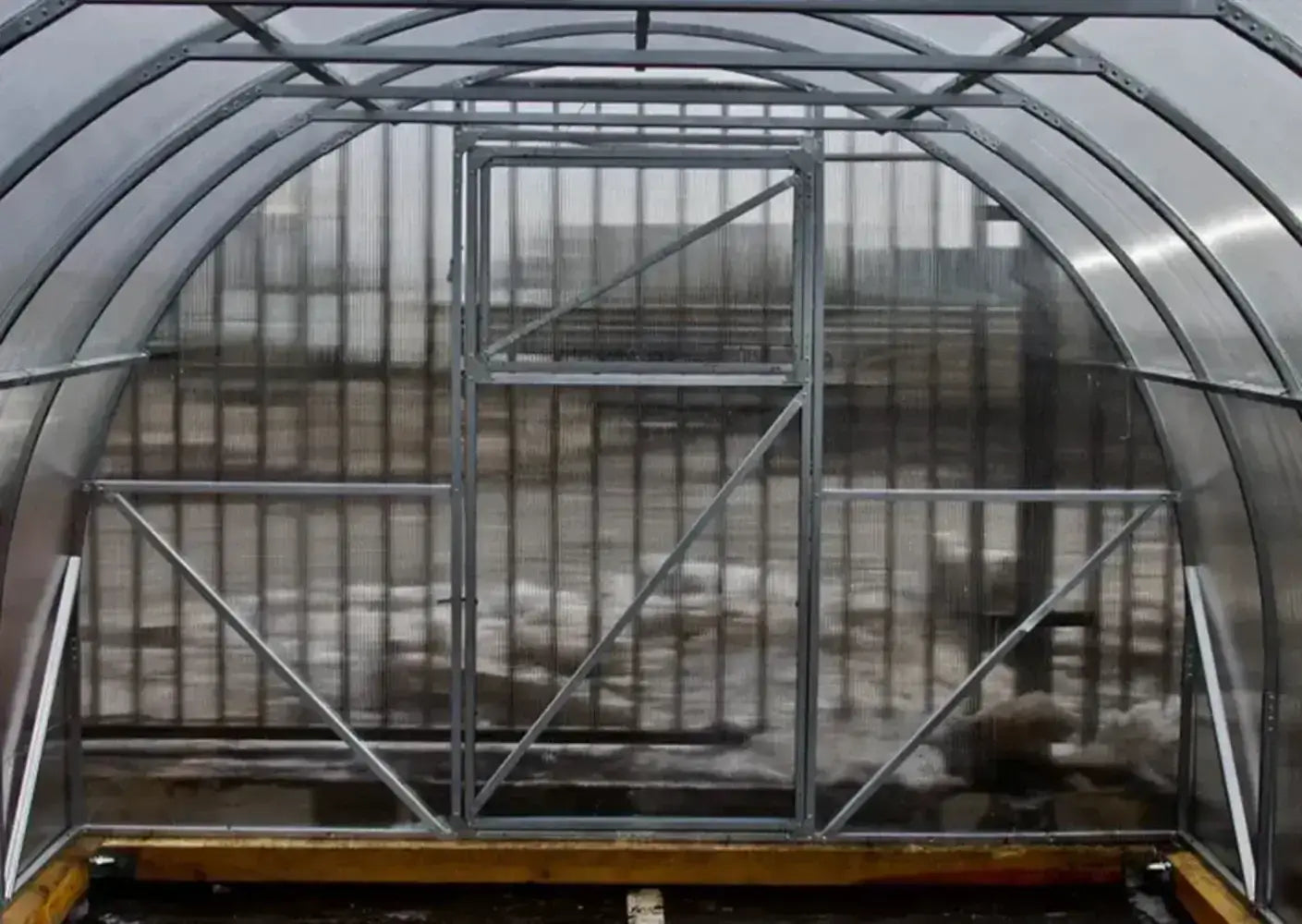 Interior view of the GreenhouseToGrow Camellia 10x13 Greenhouse Kit showing the heavy-duty galvanized steel frame and translucent polycarbonate panels.