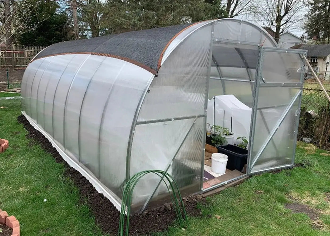 GreenhouseToGrow Camellia 10x6.5 Greenhouse Kit equipped with a black mesh shade cloth on the roof to protect delicate plants from intense summer sun.