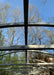 Upward-facing detail shot of the galvanized steel rafters and support frame of the GreenhouseToGrow Camellia 10x32.5 Greenhouse Kit against a clear blue sky.
