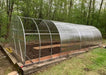 Step-by-step assembly of a Camellia 10x19.5 Greenhouse showing the polycarbonate panel installation over the curved metal frame.