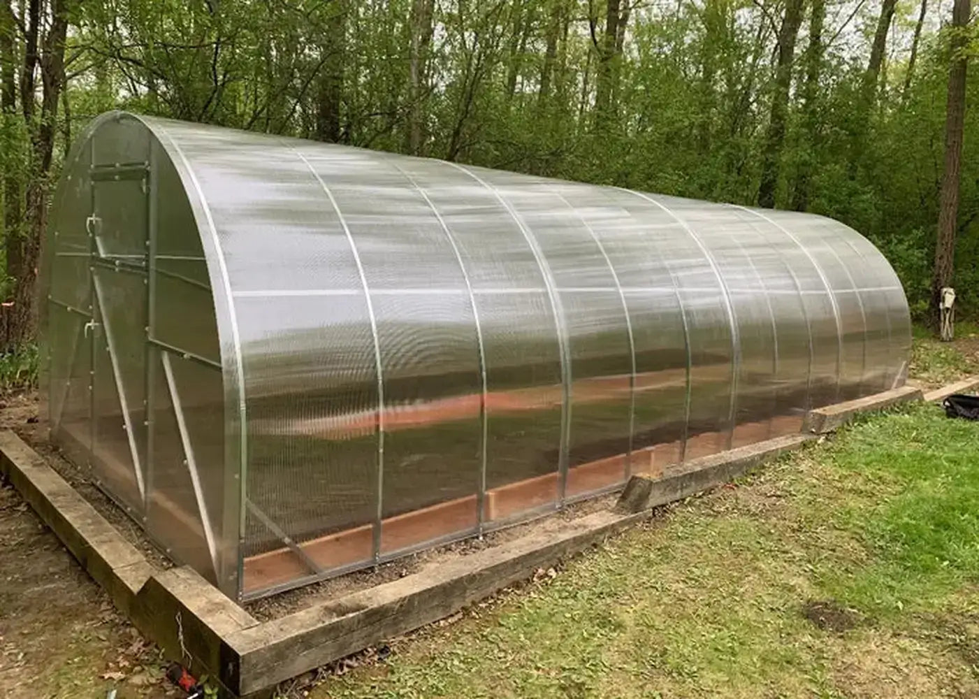 Finished GreenhouseToGrow Camellia 10x19.5 Greenhouse with translucent panels and a sturdy timber perimeter base.