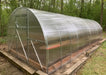 Side-angled exterior view of the fully assembled GreenhouseToGrow Camellia 10x32.5 Greenhouse Kit, showcasing the clarity of the polycarbonate panels.