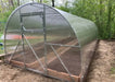 Front entrance view of the GreenhouseToGrow Camellia 10x26 greenhouse kit featuring a heavy-duty door and ventilation window.