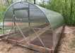 Side-profile of the GreenhouseToGrow Camellia Greenhouse Kit showcasing the long, durable polycarbonate structure designed for year-round growing.