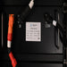 Close-up of AIMS Power lithium battery module label, COM port, B- terminal, orange connector, and black communication cable.