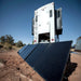 Multiple Lion Energy portable solar panels set up beside an RV in a desert campsite for mobile solar charging