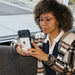 Woman using iPhone with Lion Energy Lion Claw MagSafe battery pack