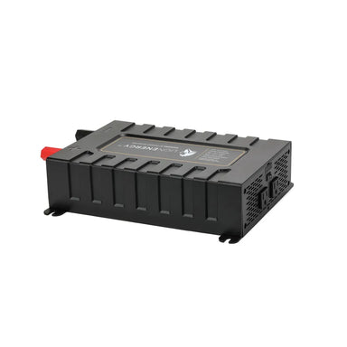 Angled studio view of the Lion Energy Savanna IV 2000W inverter, a black rectangular pure sine wave power inverter with red positive and black negative battery terminals, vented side panel, and mounting feet on a light gray background