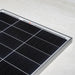 Corner perspective shot of a Rich Solar MEGA 100W 12V solar panel resting on a light-colored smooth surface.