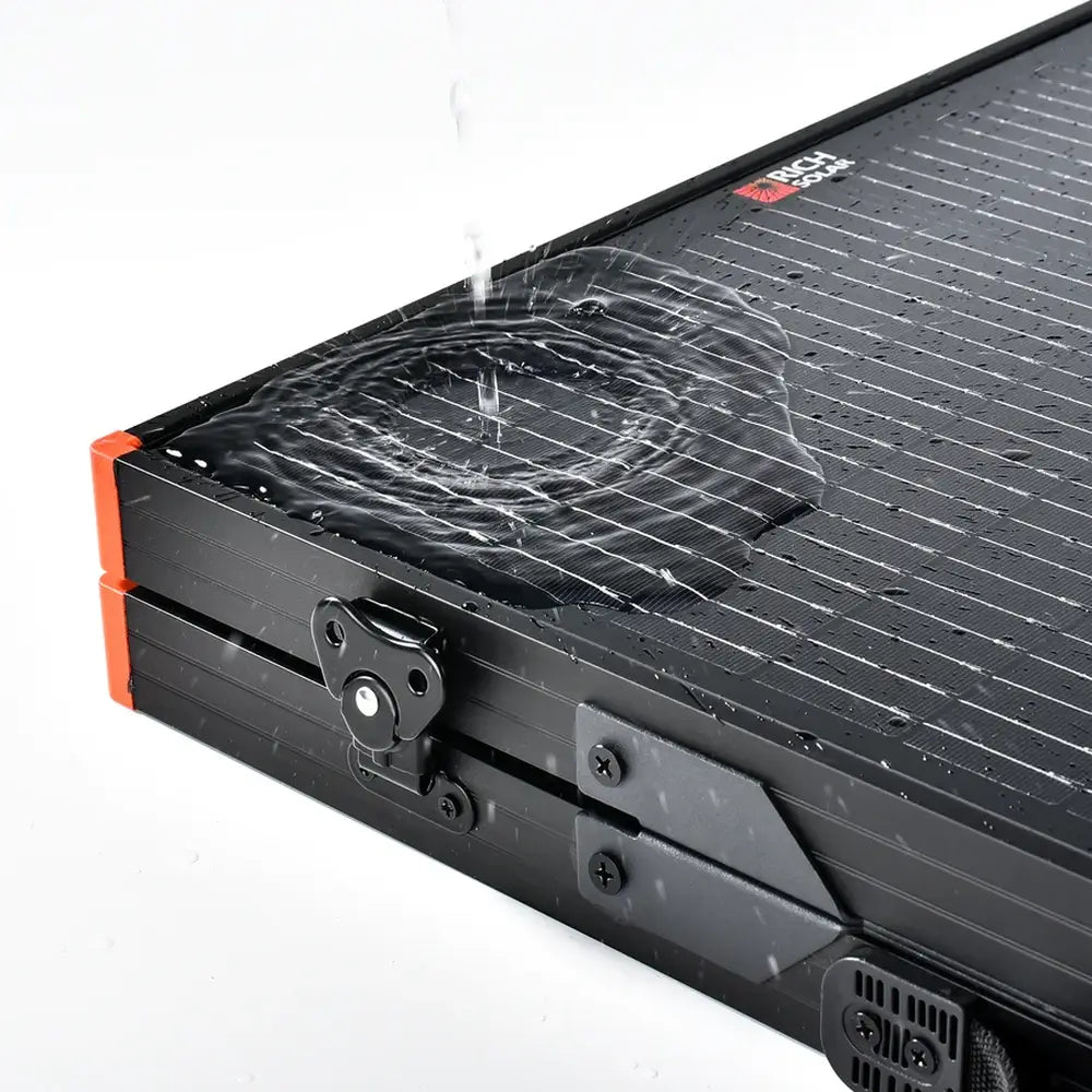 Water pouring over a folded Rich Solar MEGA 100W portable solar panel to demonstrate its waterproof and weather-resistant construction.