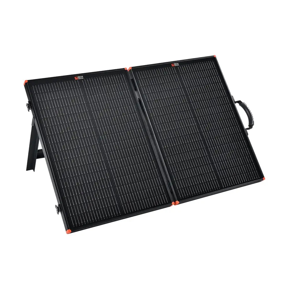 Front angle view of the Rich Solar 100W portable briefcase solar panel fully opened and propped up on its integrated kickstands for outdoor charging.