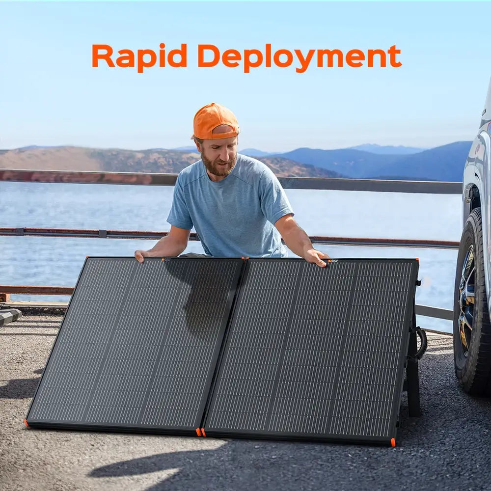 Man setting up a Rich Solar MEGA 200W portable briefcase solar panel next to an off-road vehicle with text Rapid Deployment.