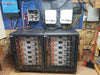 Complete DIY off-grid solar power system setup with two Rich Solar server racks filled with 48V 100Ah batteries connected to wall-mounted MagnaSine inverters.