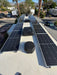 Full off-grid RV roof solar installation featuring two rows of Rich Solar MEGA 250 PRO 24V solar panels on a motorhome parked outdoors.