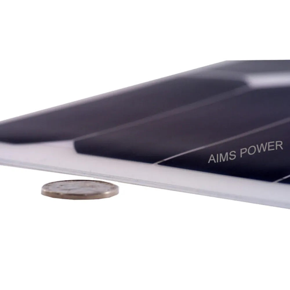 Low-angle close-up of thin AIMS Power flexible solar panel edge beside a coin, highlighting lightweight bendable construction and ultra-slim solar module design.