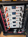 Interior view of five Rich Solar ALPHA 5 48V 100Ah solar server rack batteries wired in parallel with heavy-duty red and black power cables.