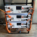 Three Rich Solar 48V 100Ah lithium iron phosphate server rack batteries stacked in an open metal frame and connected with thick orange power cables.