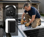A man wearing work gloves installs a solar panel on a campervan roof with inset graphics showcasing the pre-wired junction box loop and the sleek black corner frame design.