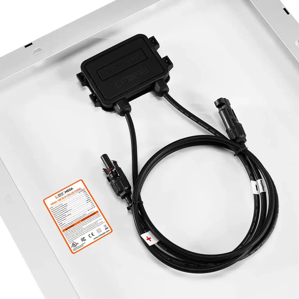High-angle detail of coiled positive and negative solar cables with MC4 connectors attached to the junction box of a Rich Solar 100W slim panel.