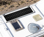 Close-up overhead view of a Rich Solar MEGA 130W Slim Solar Panel mounted on a white camper roof next to skylights and an antenna.